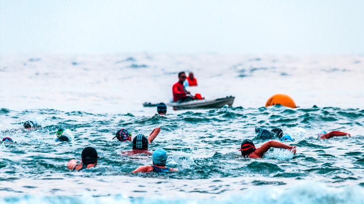 Atletas na fase aquática, podendo ser de 500m ou 1km na modalidade completa ou 2km de natação.